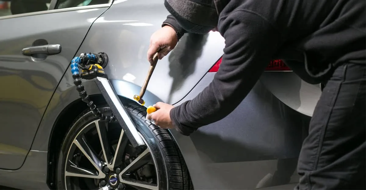 Working a dent out of a rear fender under a body light