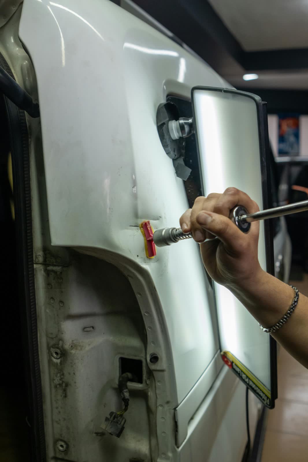 Pulling a dent out of a truck panel under a body light