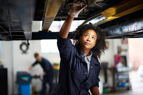 A mechanic checking a vehicle over from underneath