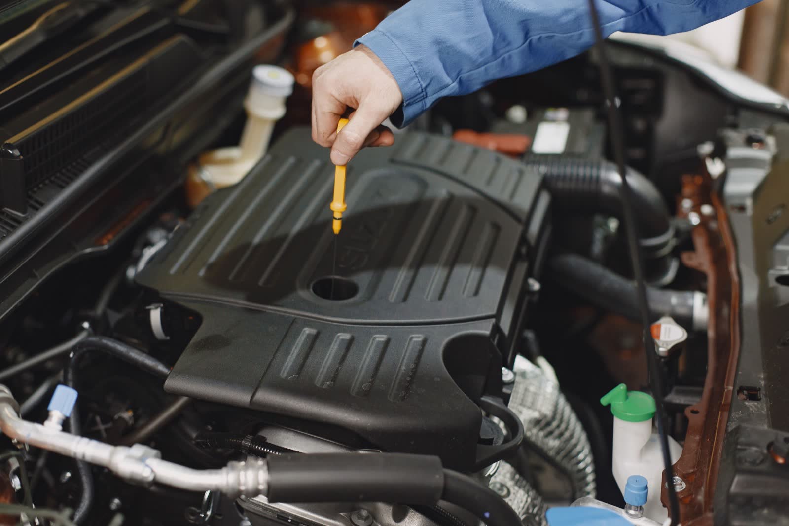 Pulling the dipstick to check the oil