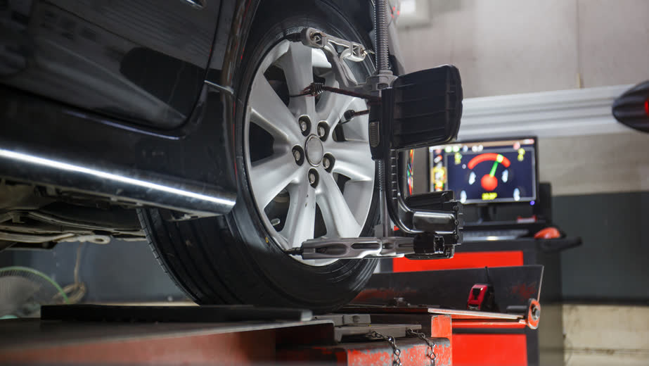 A car on the alignment rack with optical targets on the wheels