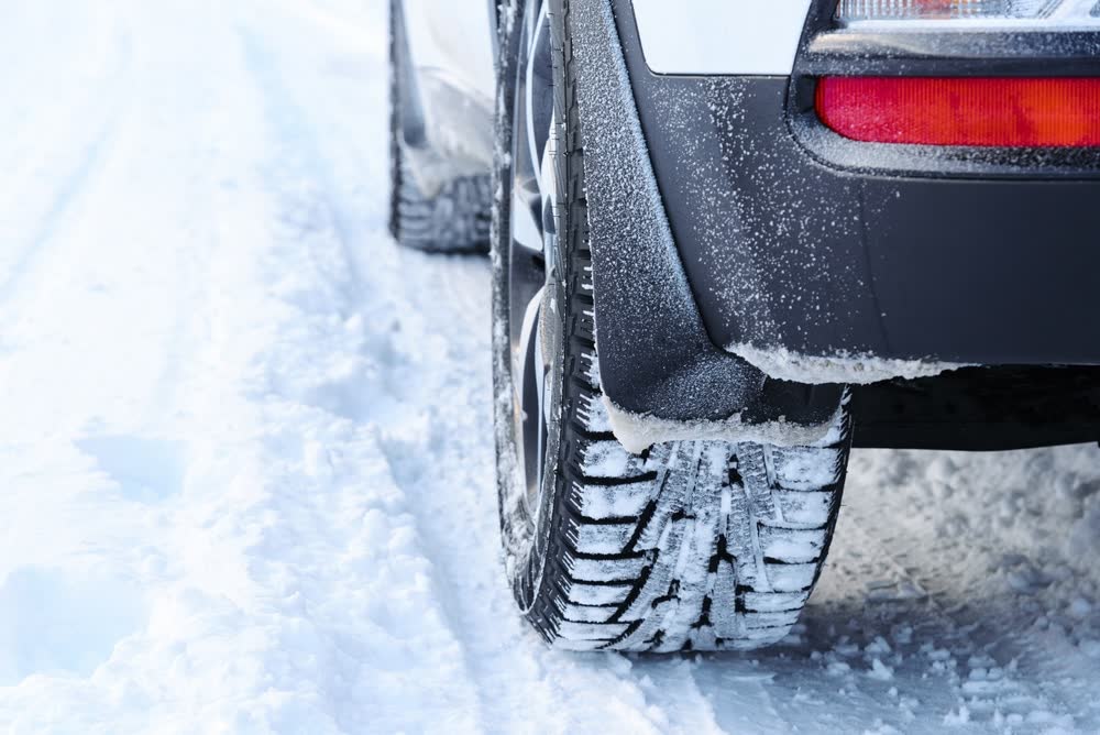 Winter tires on a vehicle parked in the snow