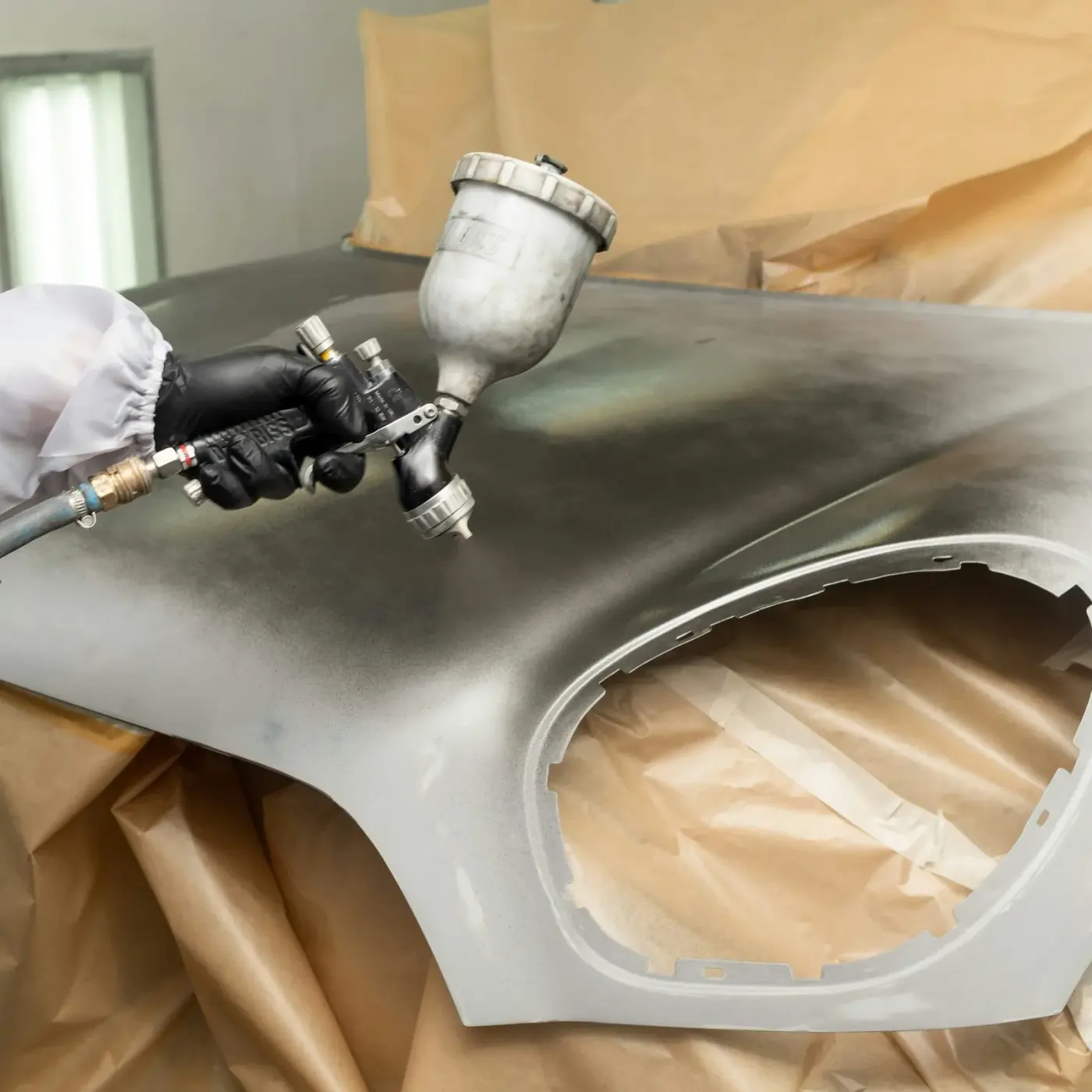 Spraying a hood laid out on paper